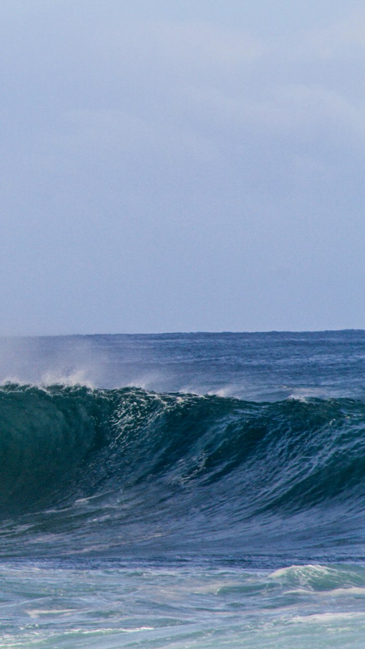 Vague qui se creuse sous un ciel gris